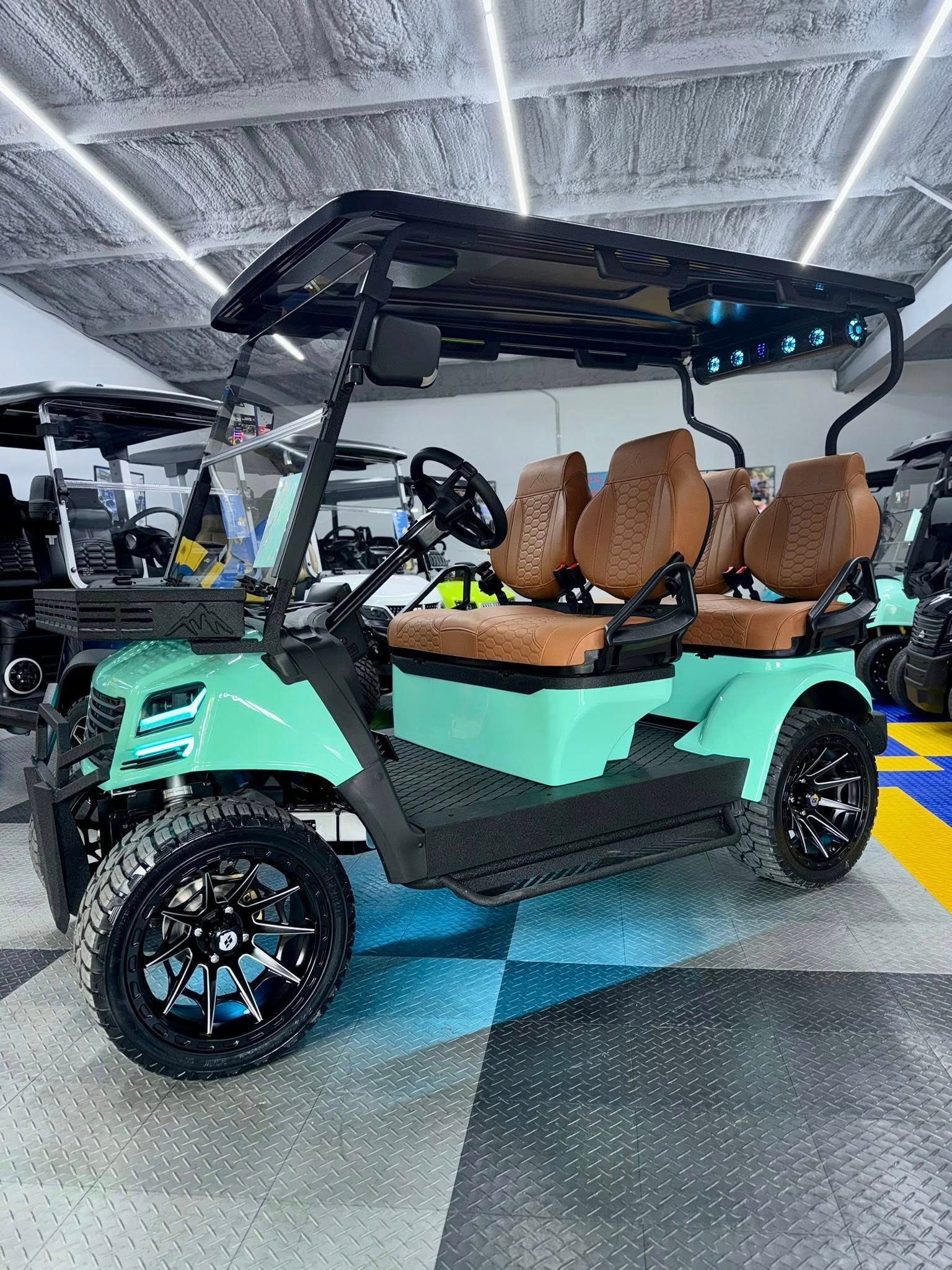 Mint green golf cart with black trim, brown seats, and black wheels, parked inside a showroom.