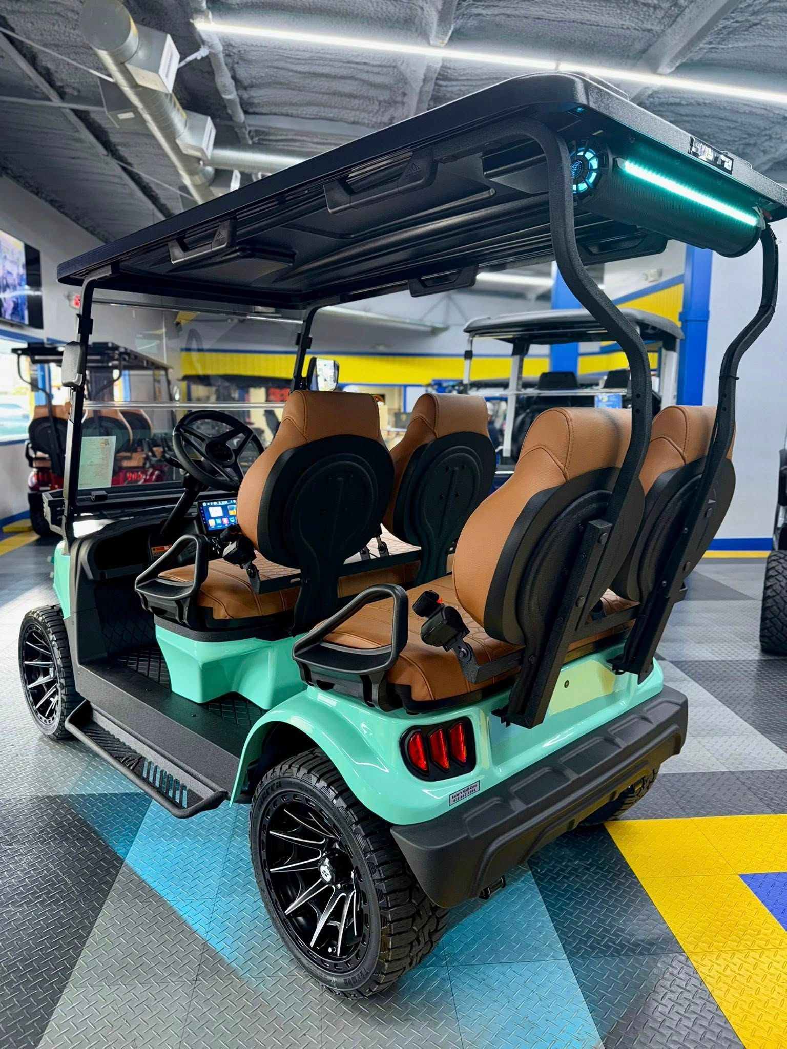 Mint green golf cart with brown seats, black roof, and black wheels.