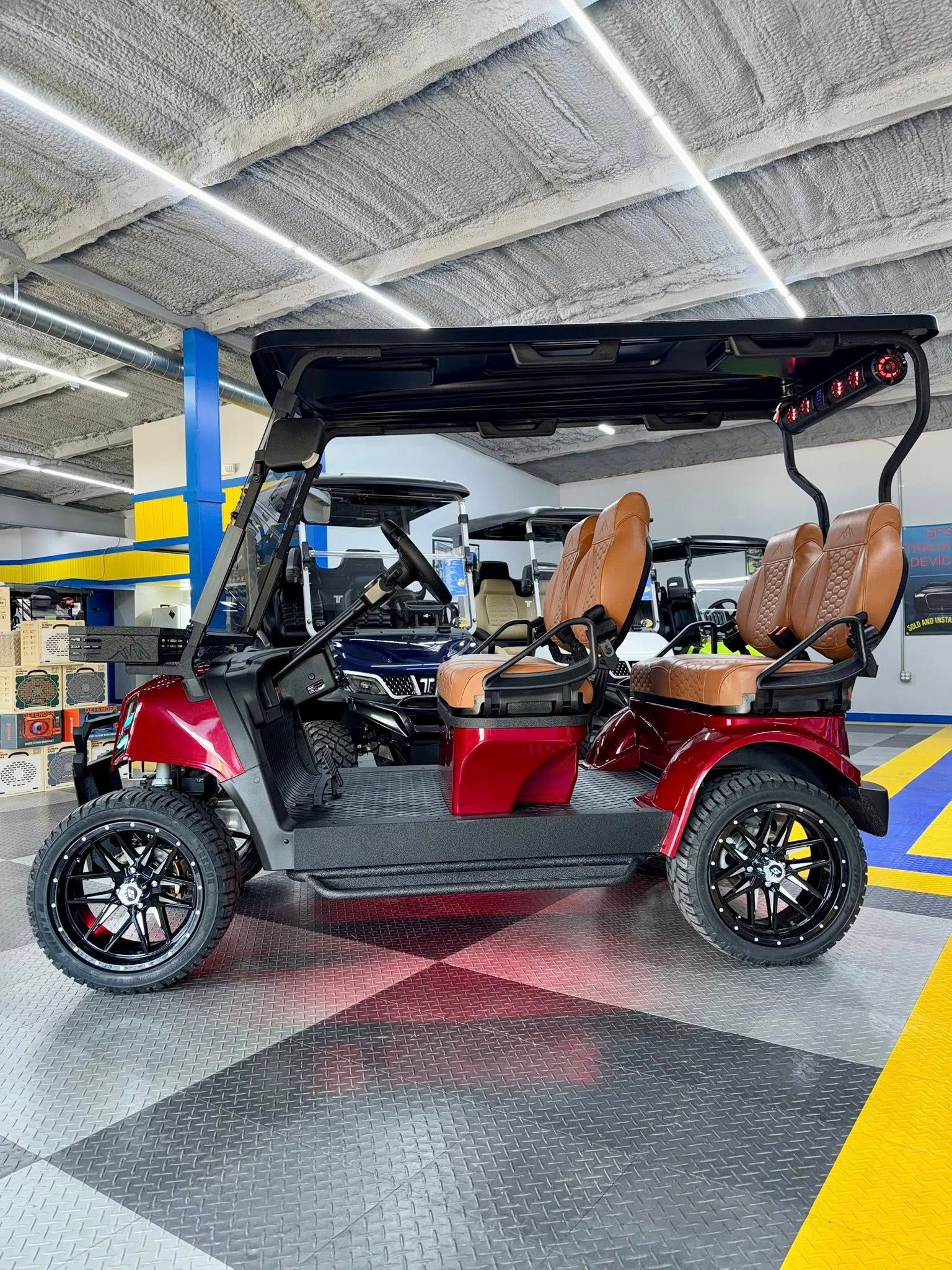 Red golf cart with brown seats and black wheels on a checkered floor.