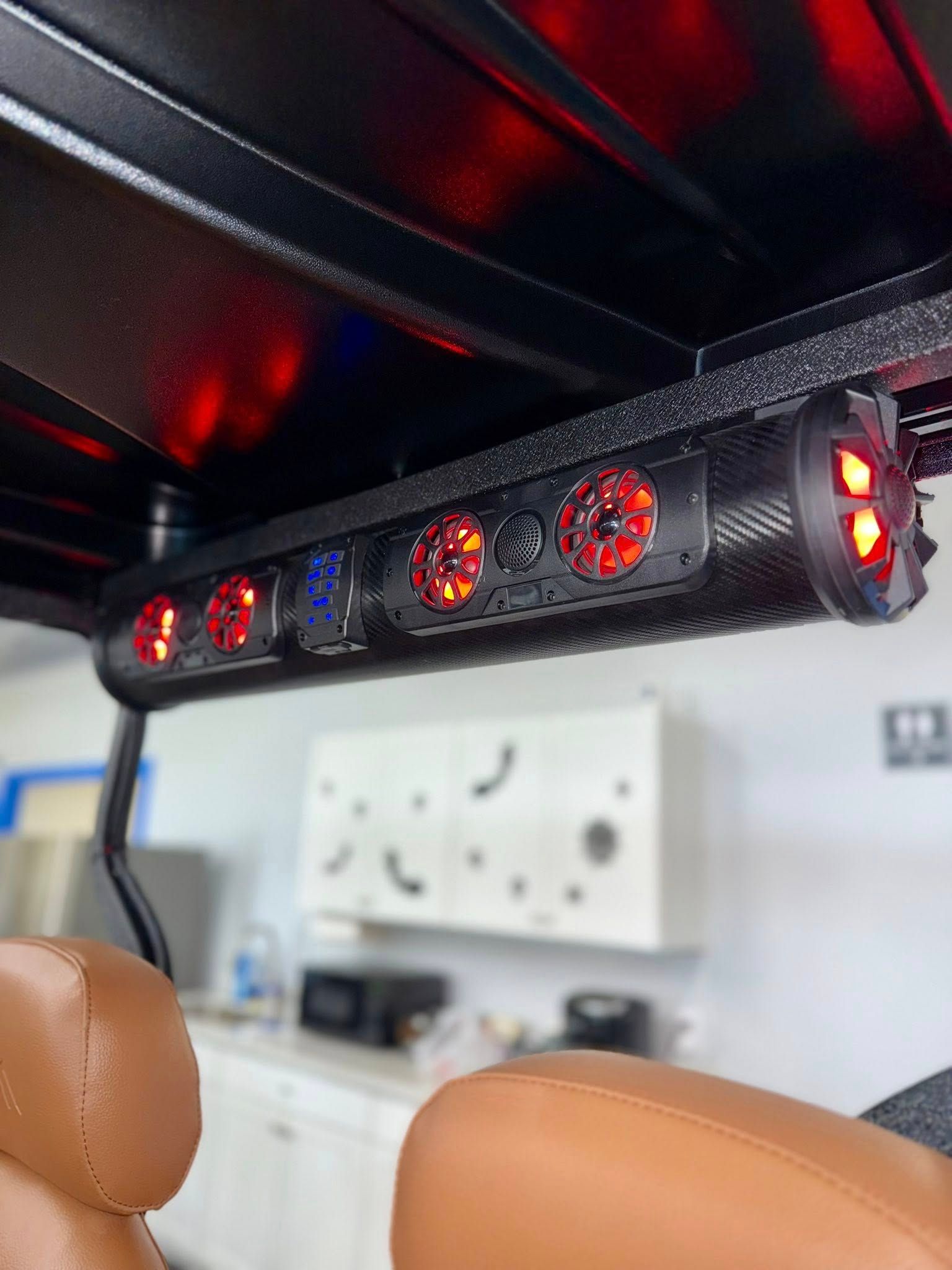 Golf cart with speaker bar featuring red LED lights, brown seats.
