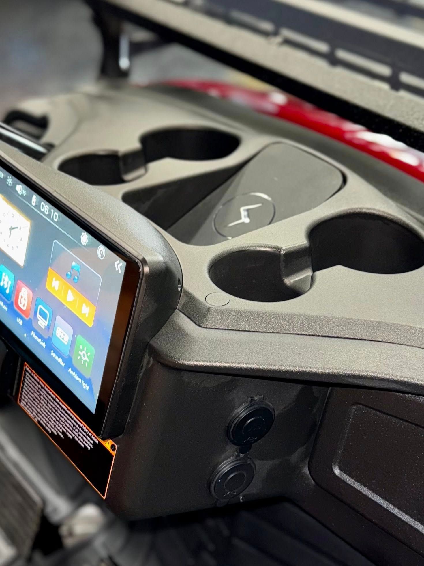 Golf cart console with a touchscreen, cup holders, and charging ports.