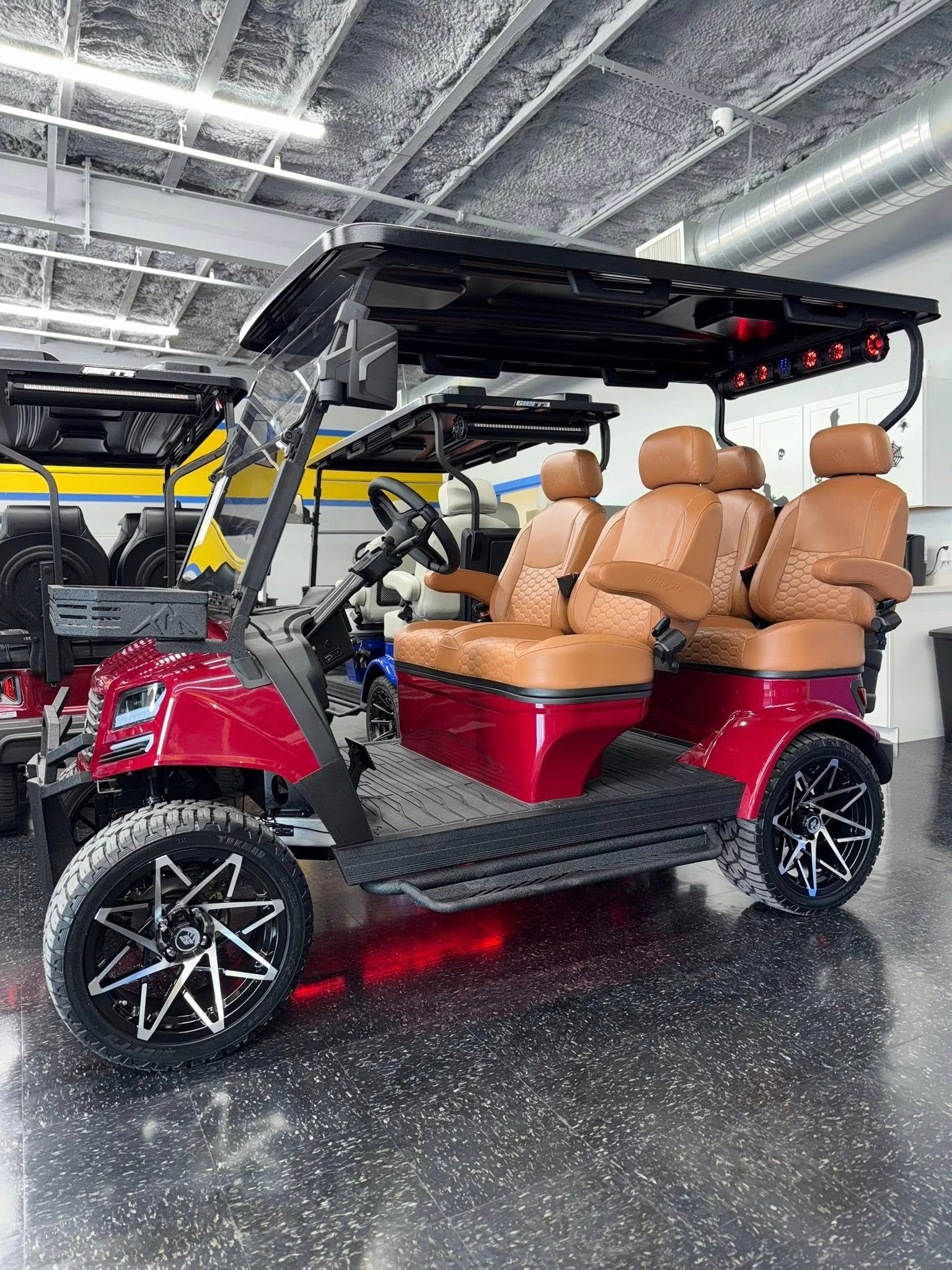 Red golf cart with black roof and brown leather seats.