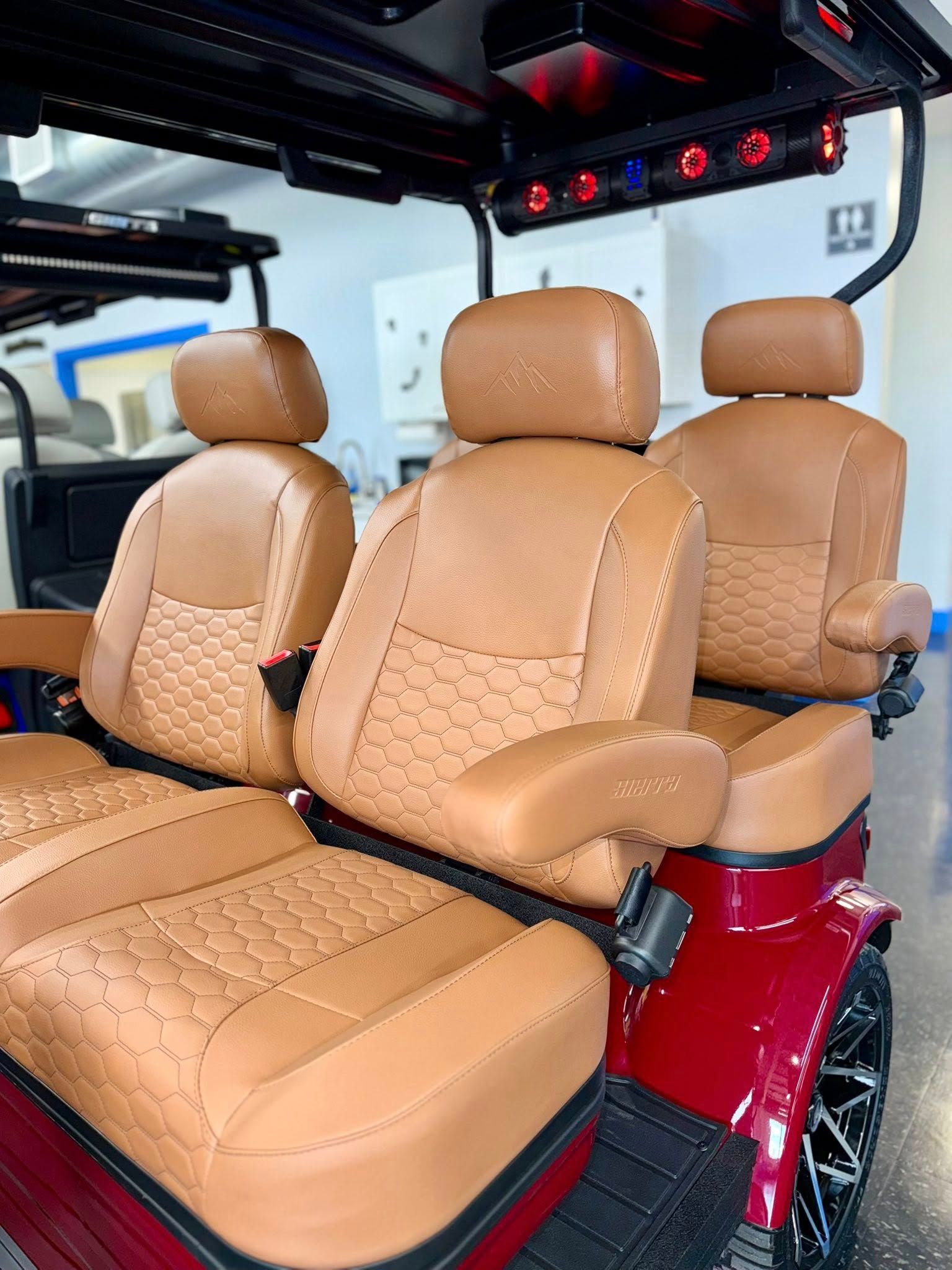 Red golf cart interior with tan leather seats, red accent, and black trim.