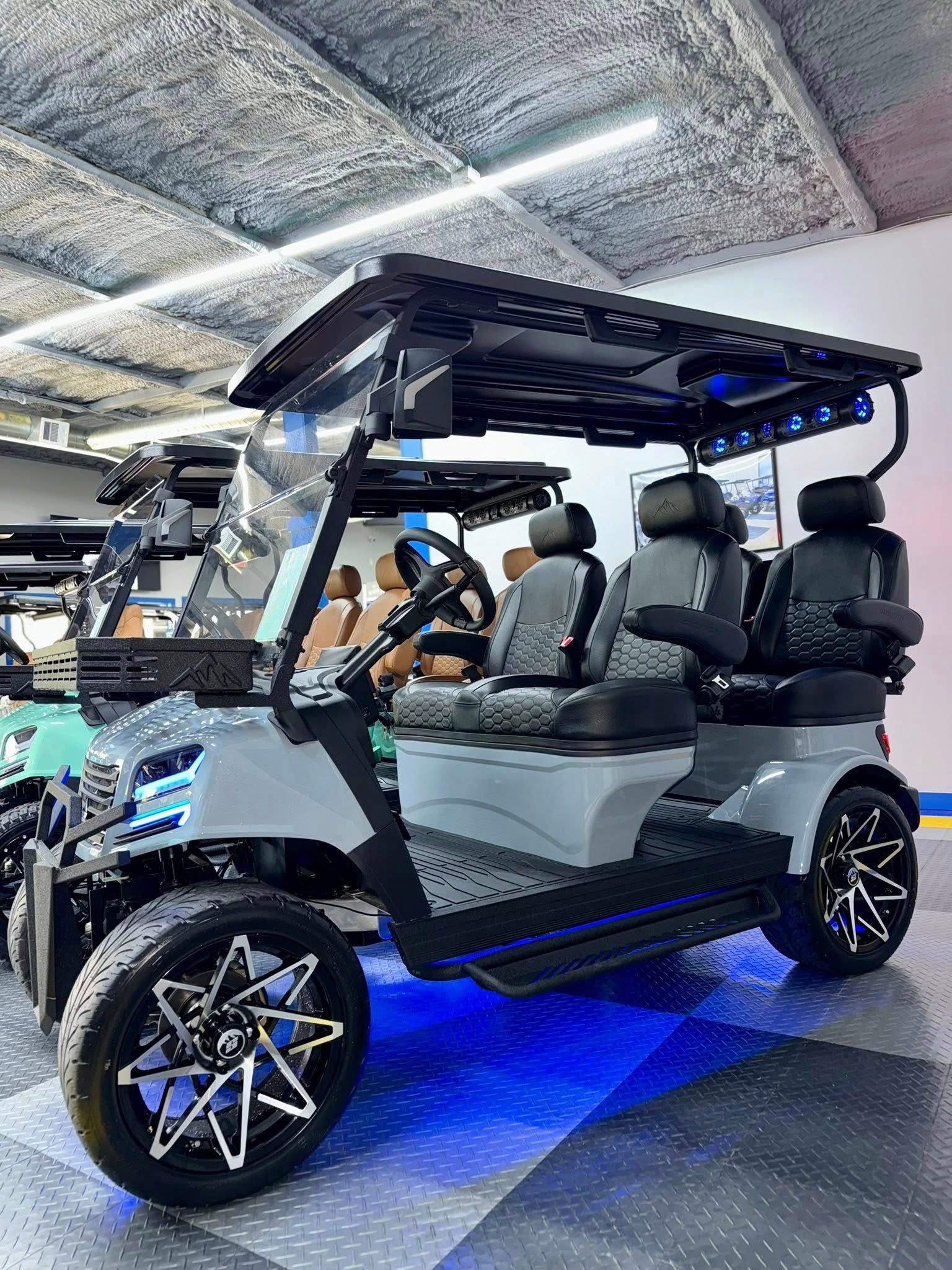 Gray and black custom golf cart with black wheels, in a showroom.