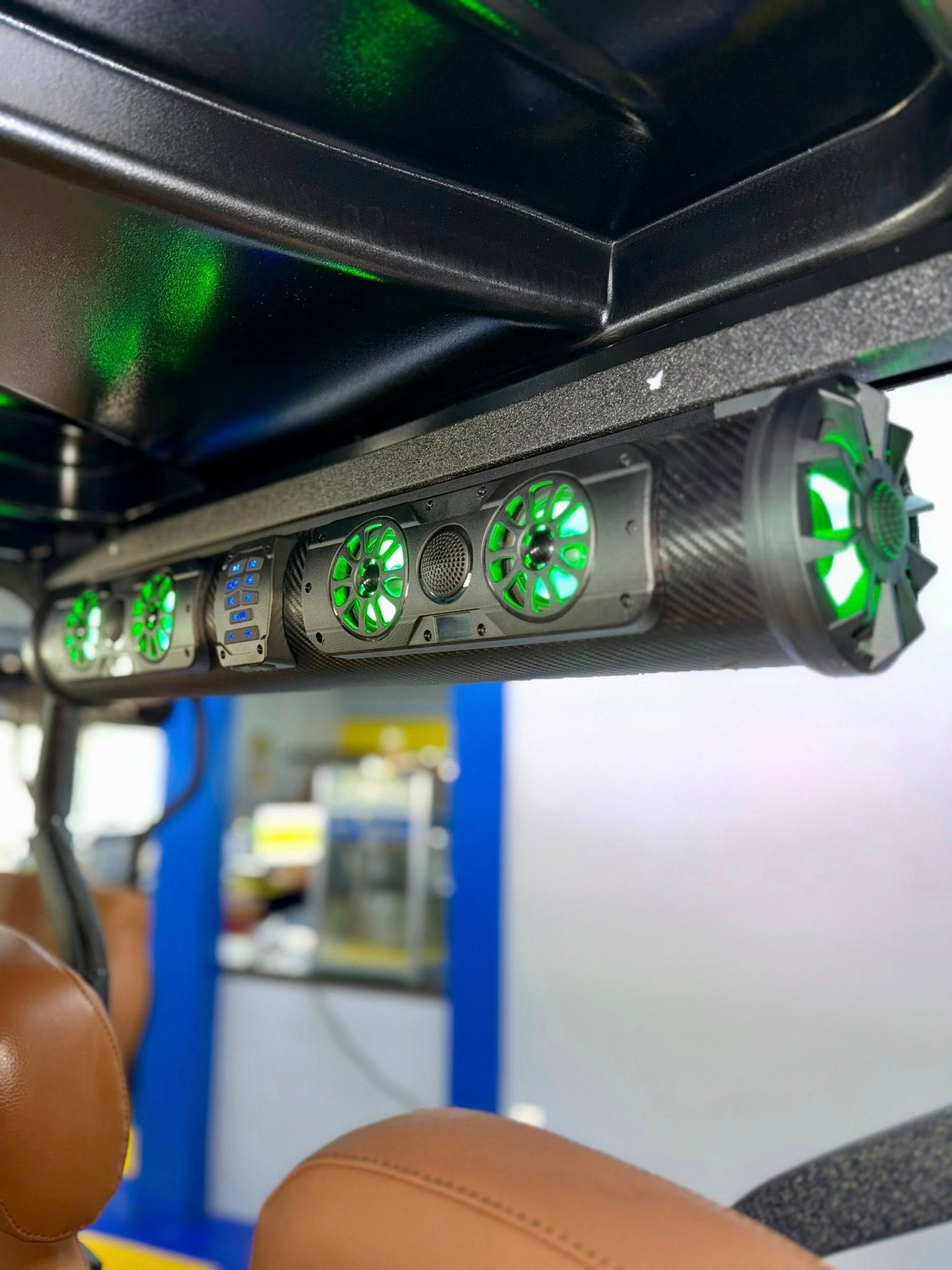 Golf cart soundbar with green LED lights, carbon fiber design, mounted under the roof.