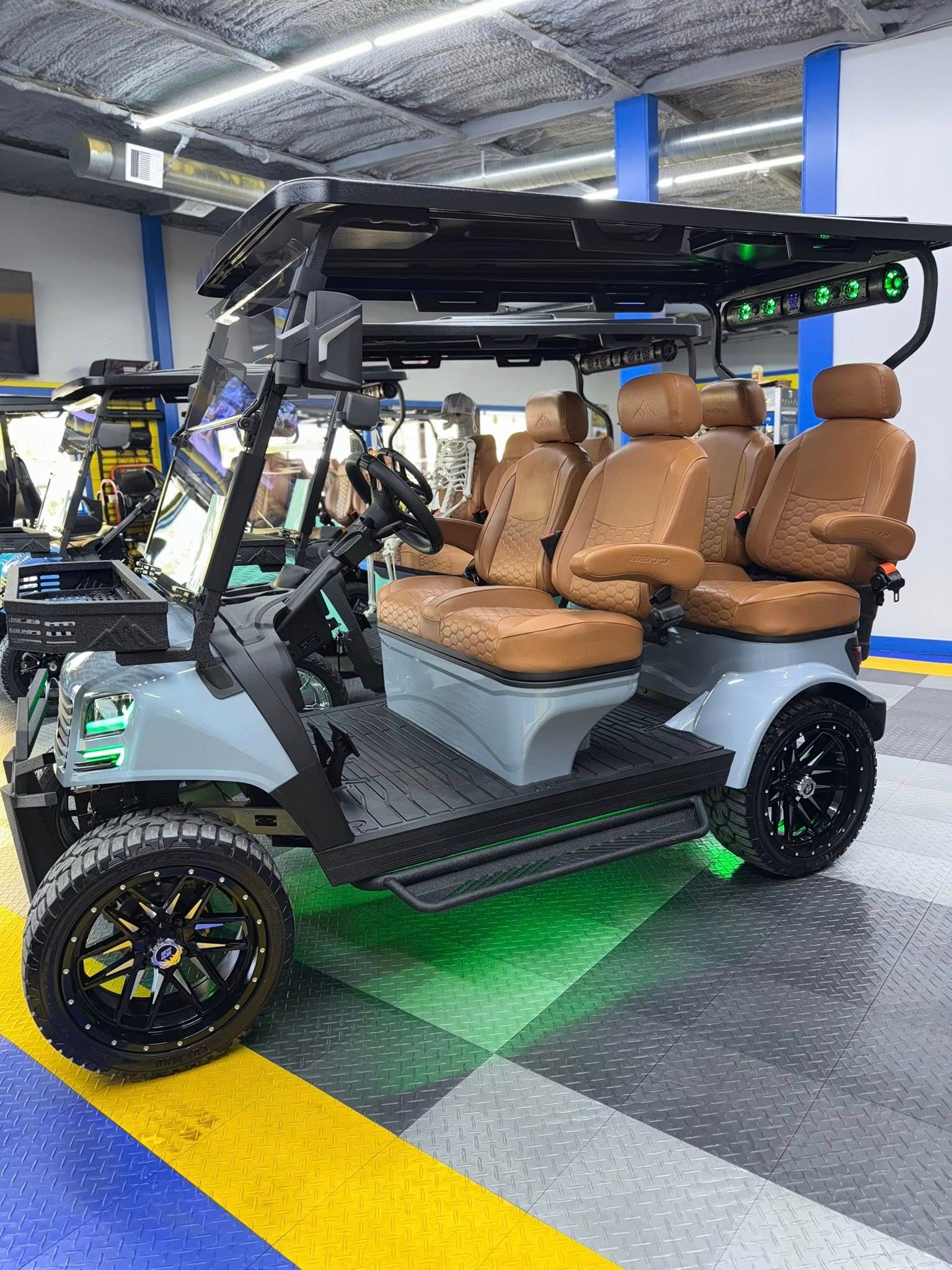 Gray golf cart with brown seats, black wheels, and green underglow.
