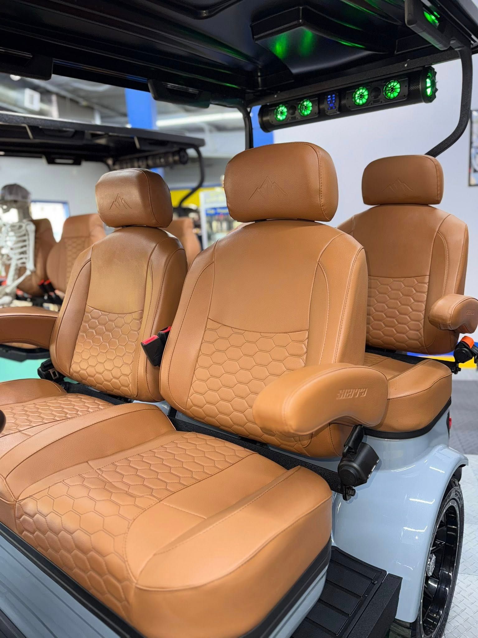 Brown leather seats in a golf cart with custom lighting, displayed in a store.