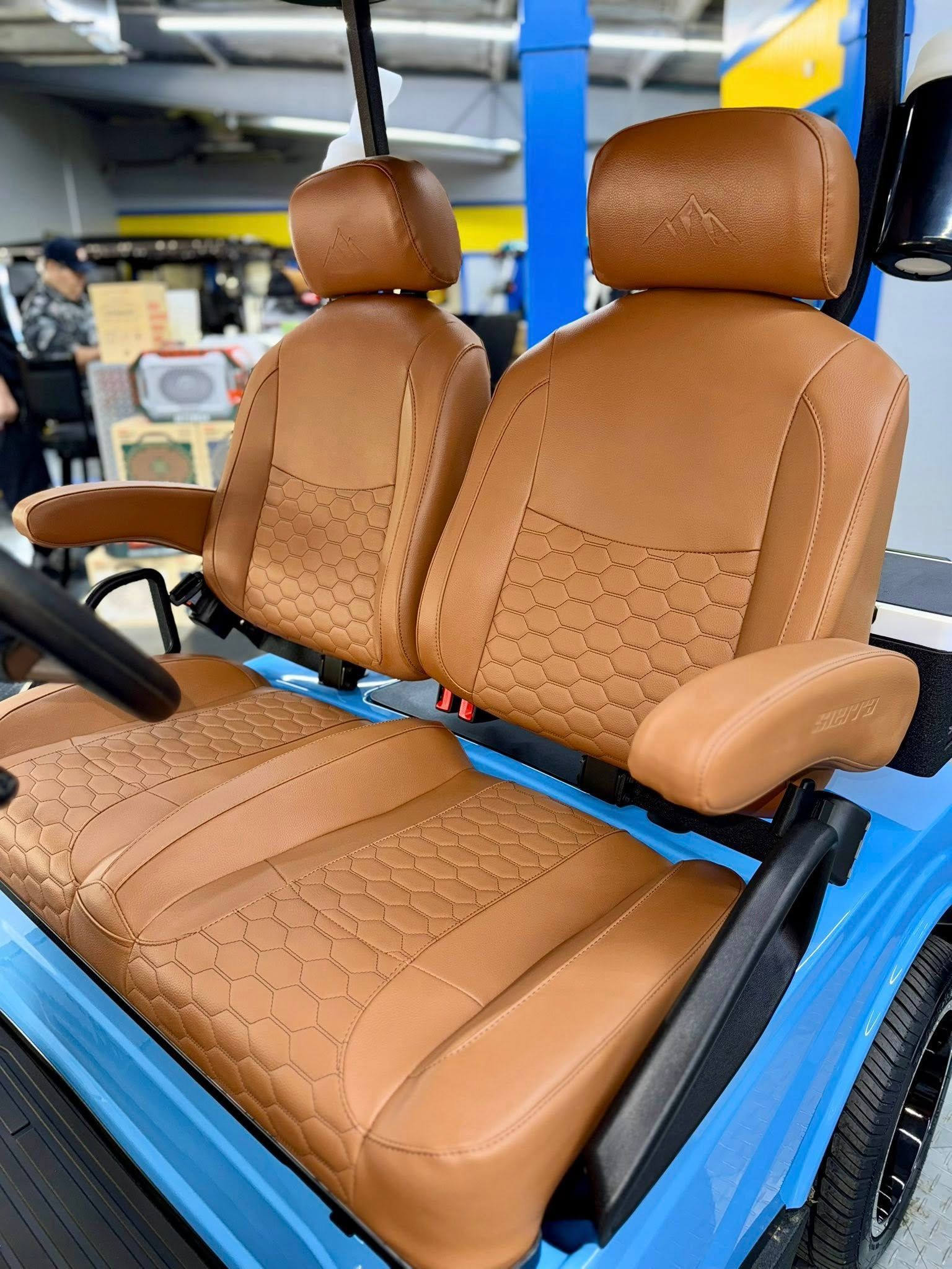 Tan leather seats in a blue golf cart.