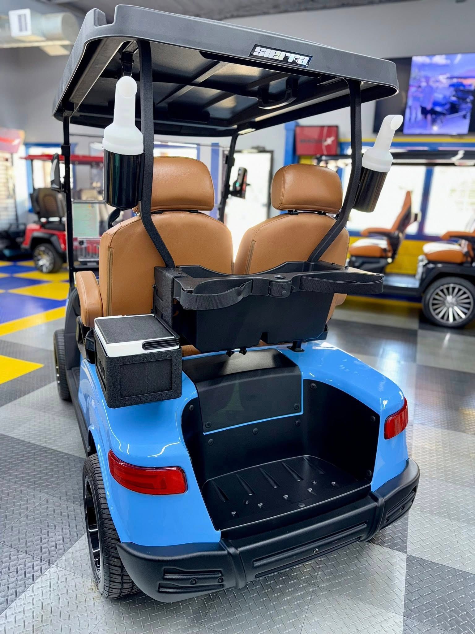 Blue golf cart with brown seats and a black roof in a showroom.