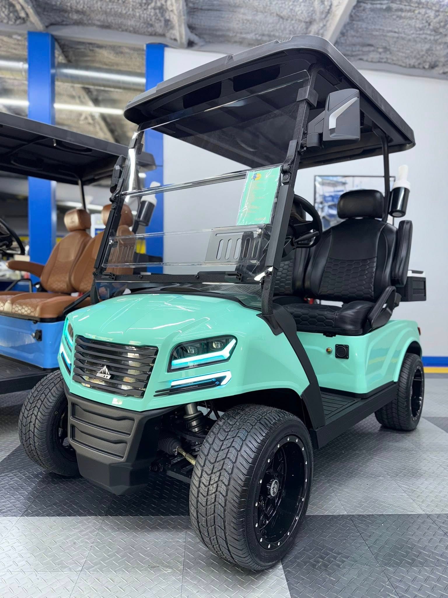 Mint green golf cart with black trim and wheels parked inside a showroom.