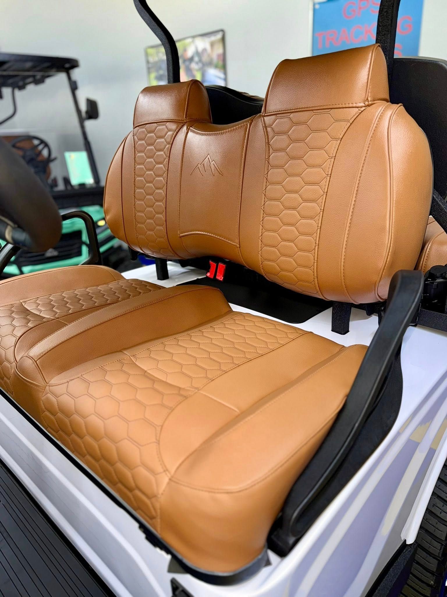 Tan leather golf cart seats with a geometric pattern.