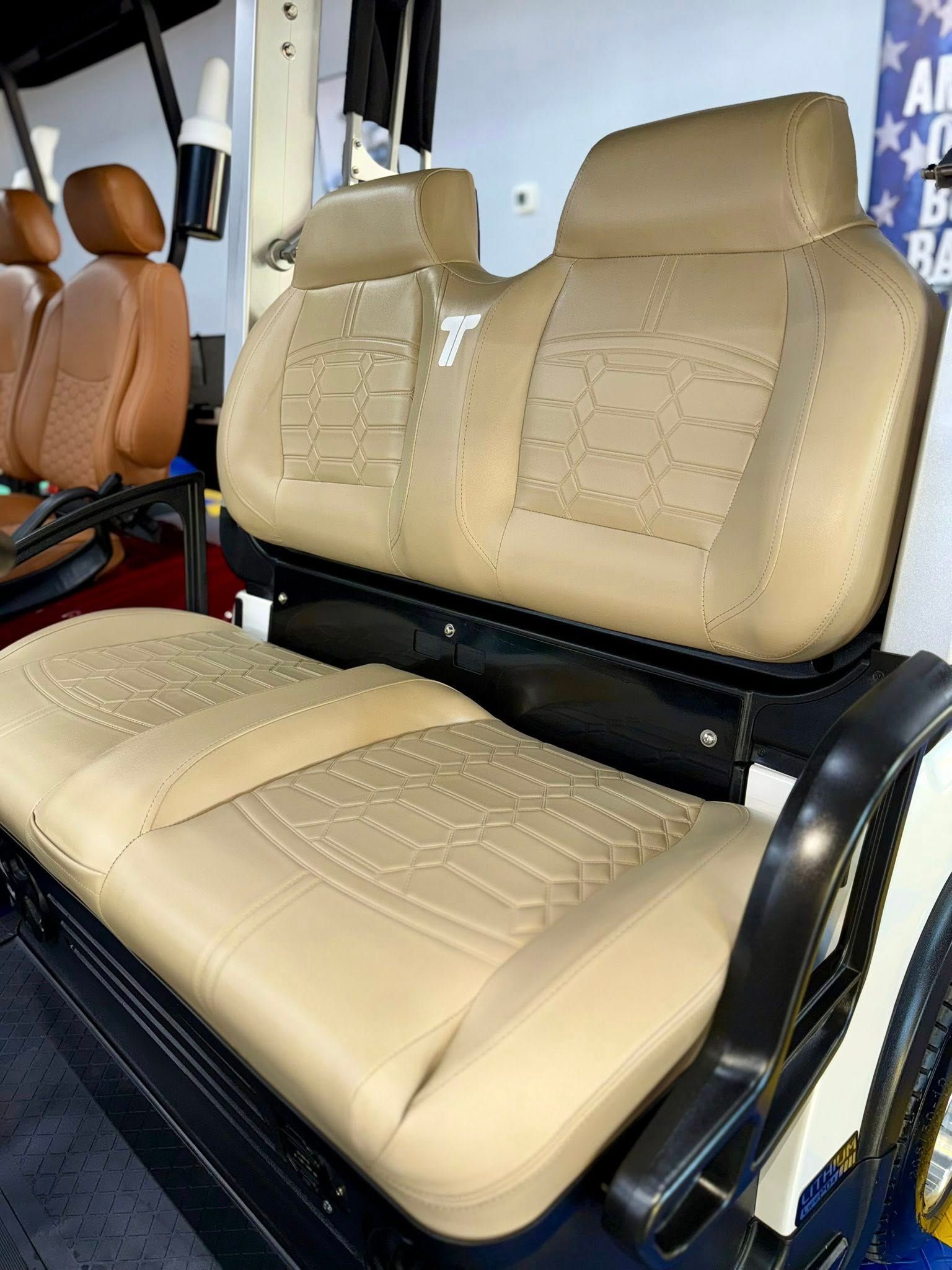 Tan golf cart seats with quilted patterns, indoors.