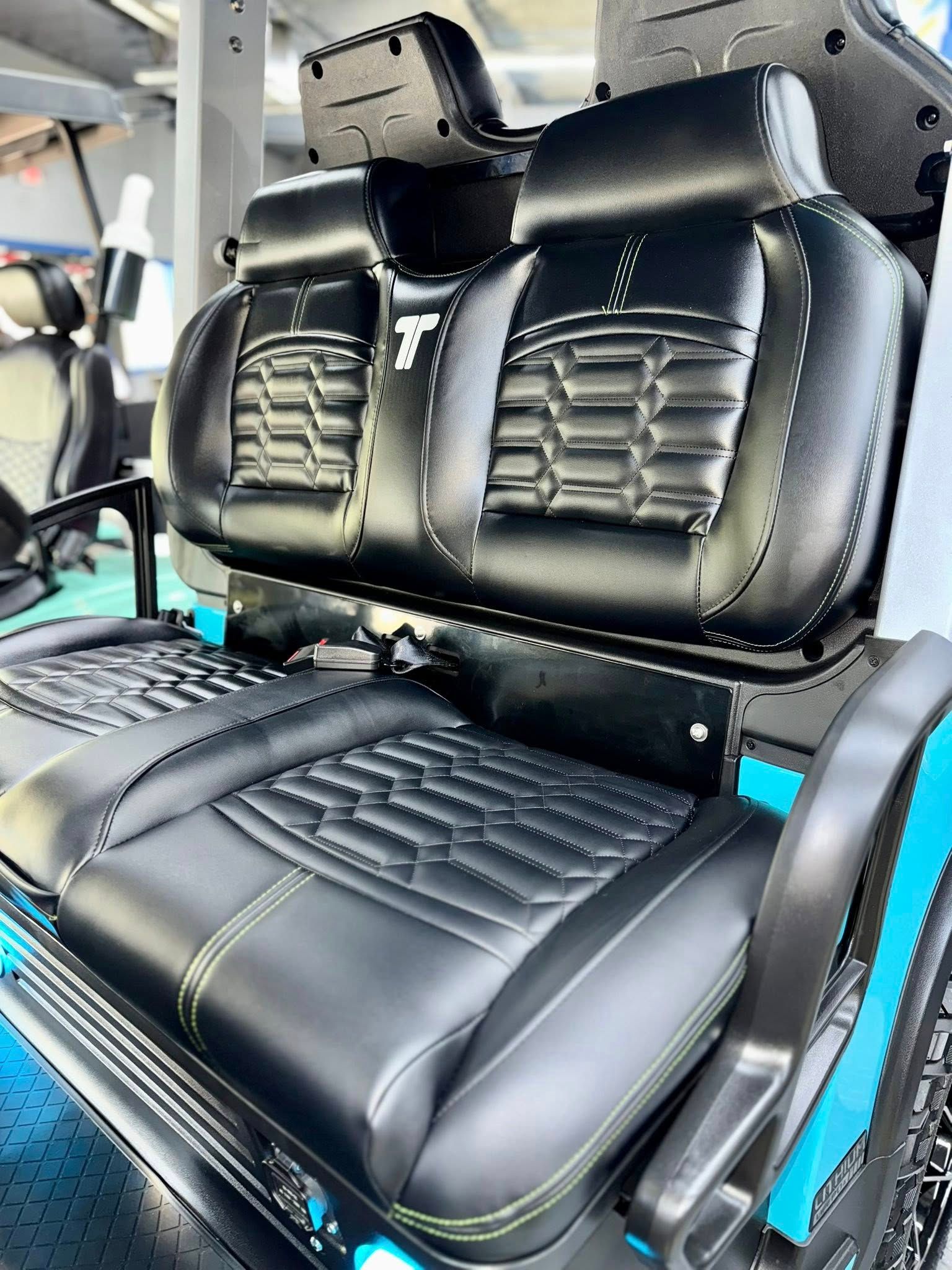 Black leather golf cart seats with blue and green accents.