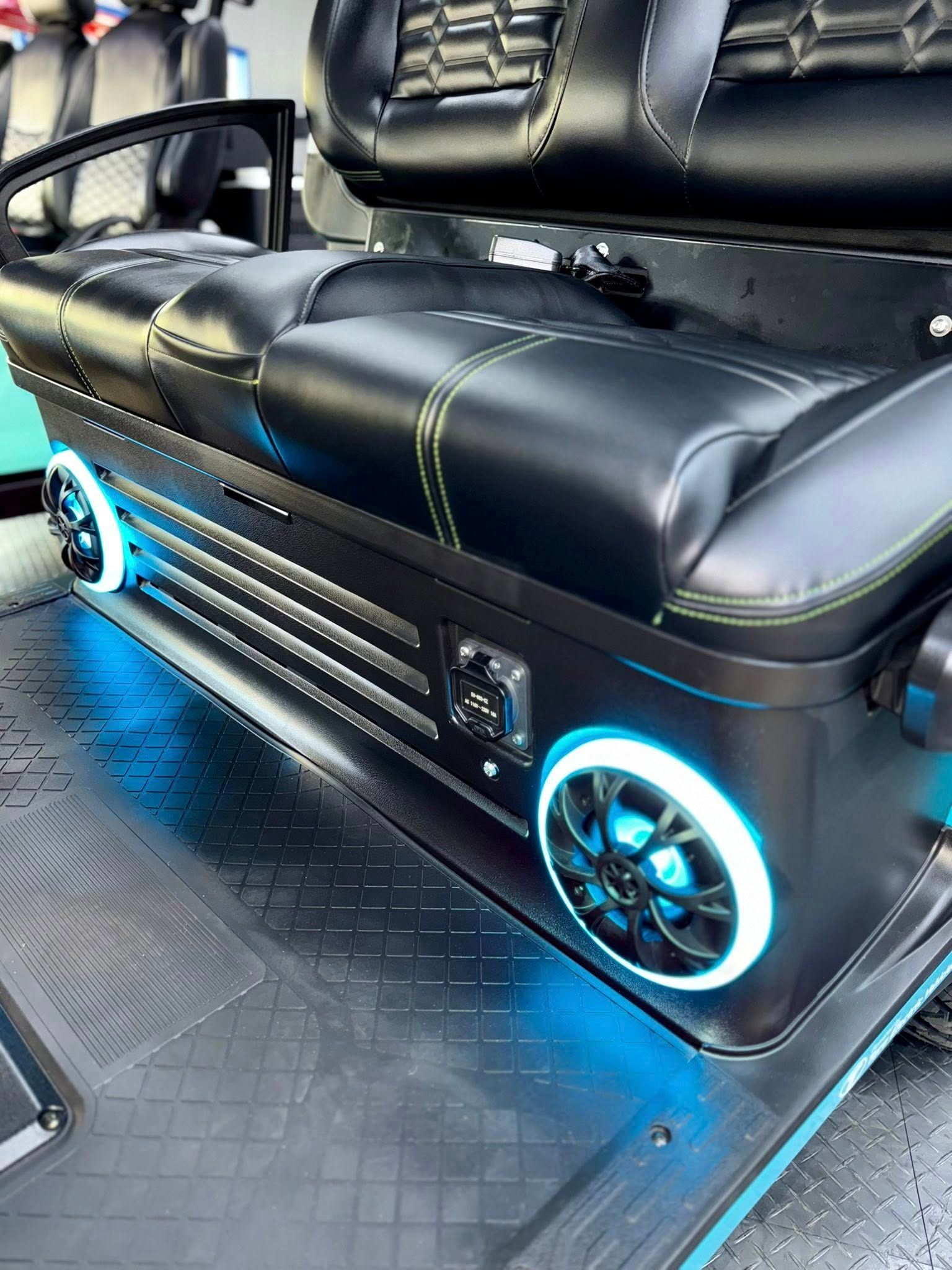 Custom golf cart seat with black leather and blue LED lights.