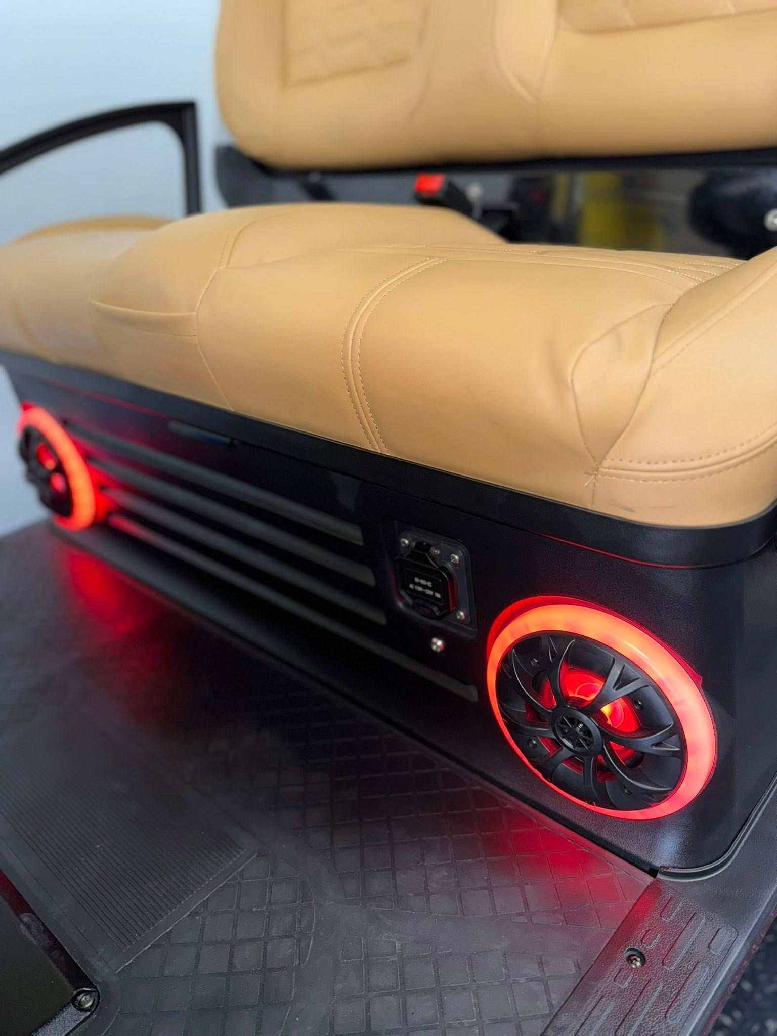 Tan golf cart seat with red LED speakers and black trim.