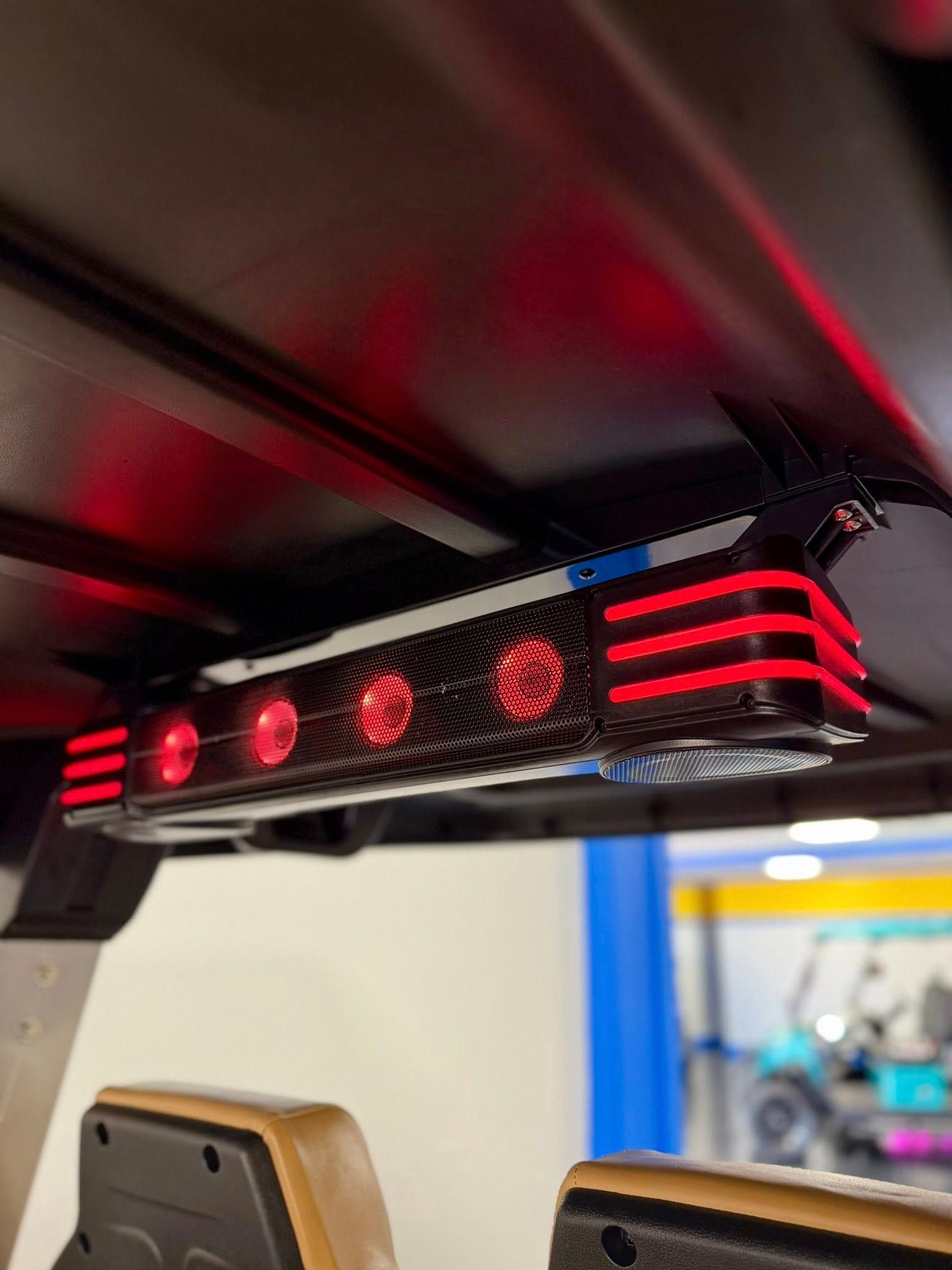 Red LED lights mounted under the roof of a vehicle, likely a golf cart, illuminating the interior.