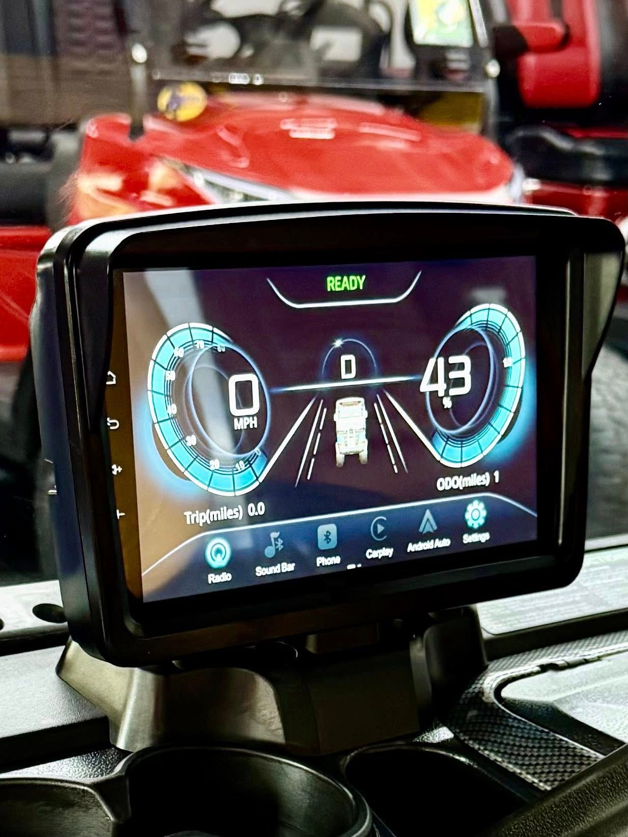 A digital dashboard displaying speed at 0 and 43 mph, with icons, mounted in a golf cart.