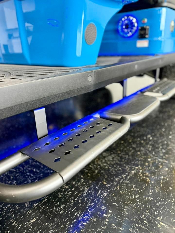 Blue golf cart with illuminated side steps.