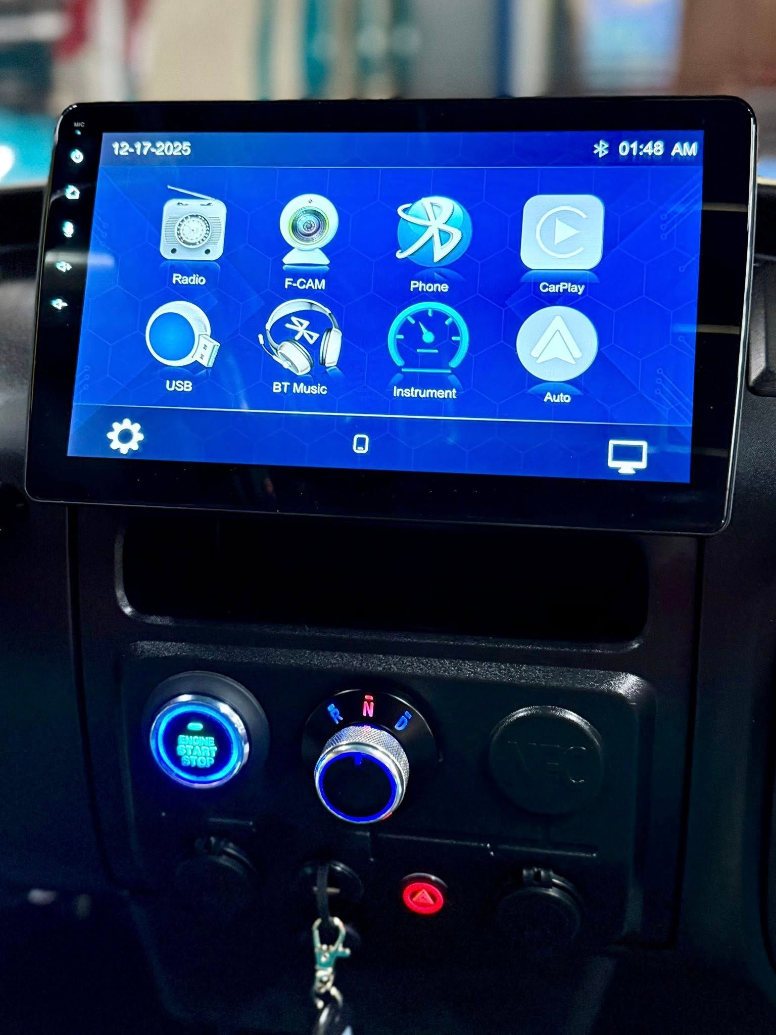 Car dashboard with a touchscreen display, illuminated knobs, and icons on the screen.