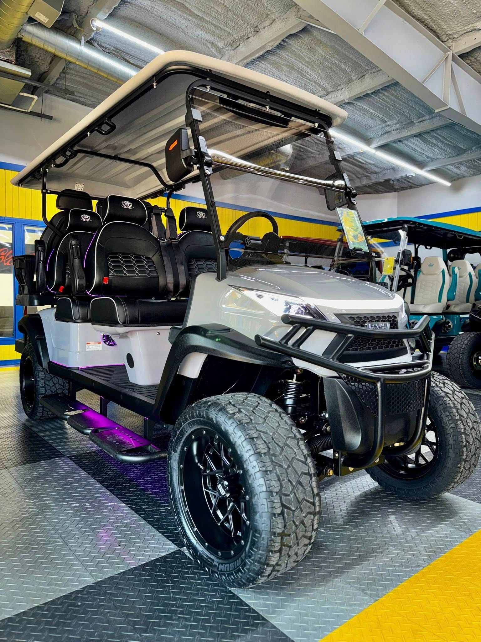 Gray golf cart with black wheels, lifted suspension, and purple underglow.