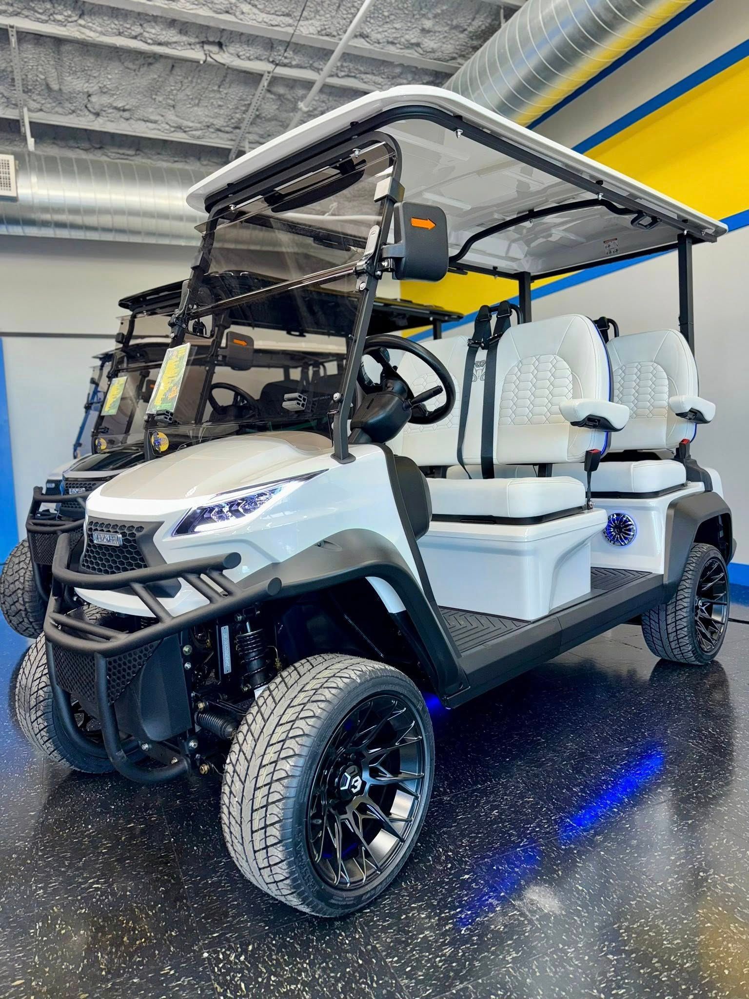 Gray golf cart with black accents, sitting inside a showroom with blue and yellow accents.
