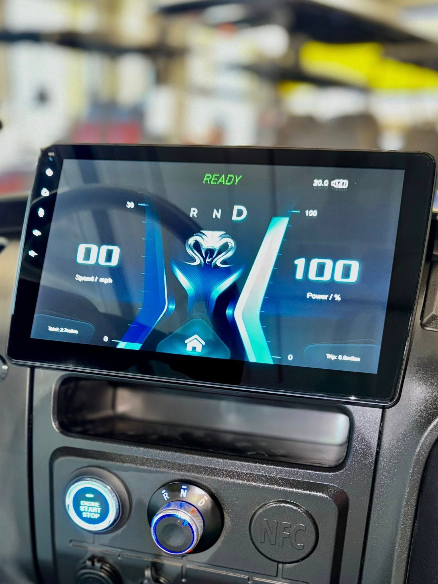 Dashboard with large digital display showing speedometer, gear selection, and power level in a vehicle.