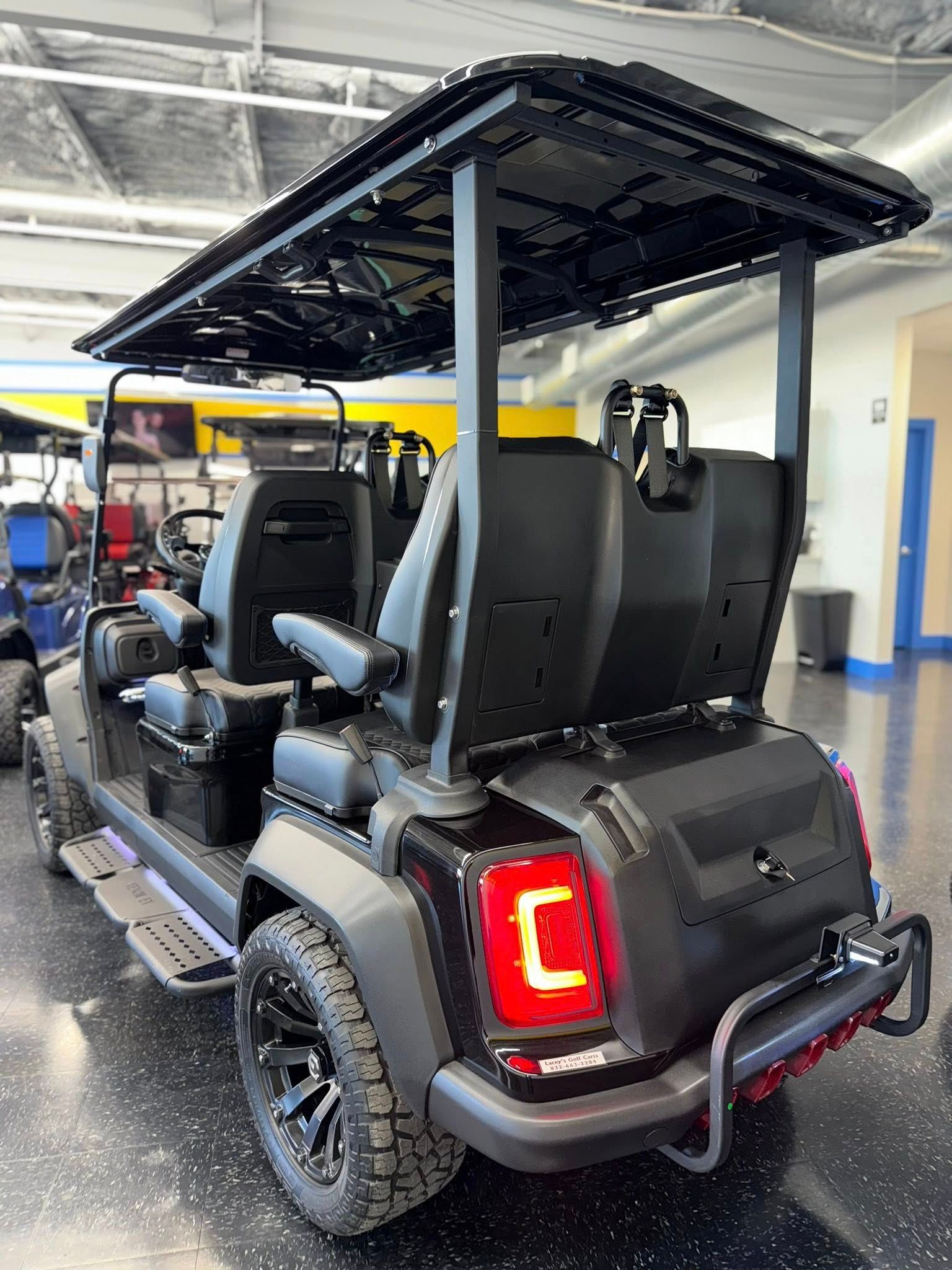 Black golf cart with black roof, black wheels, and bright taillights.