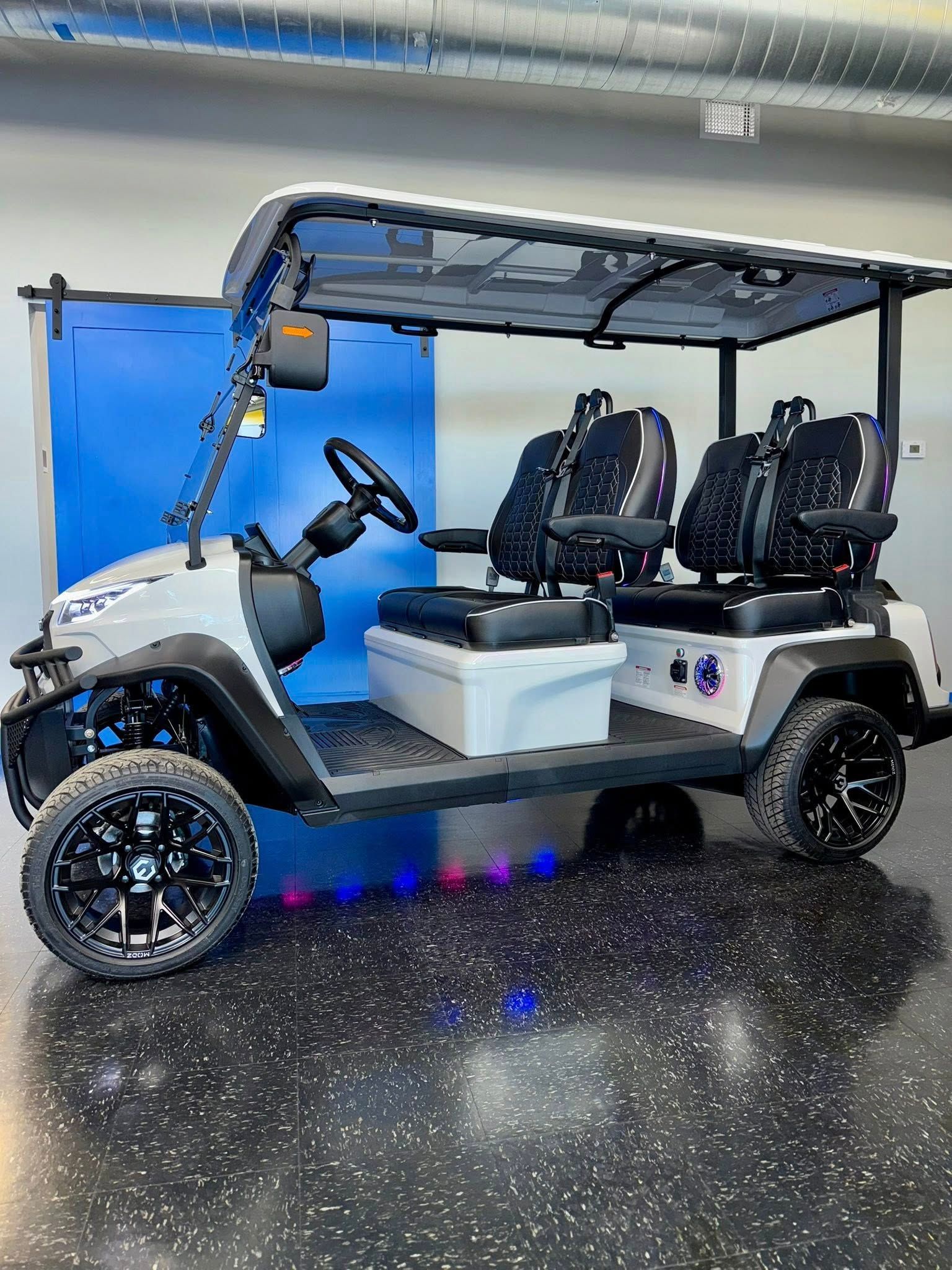 Gray and black custom golf cart with black wheels, seating for four, and underglow lights.