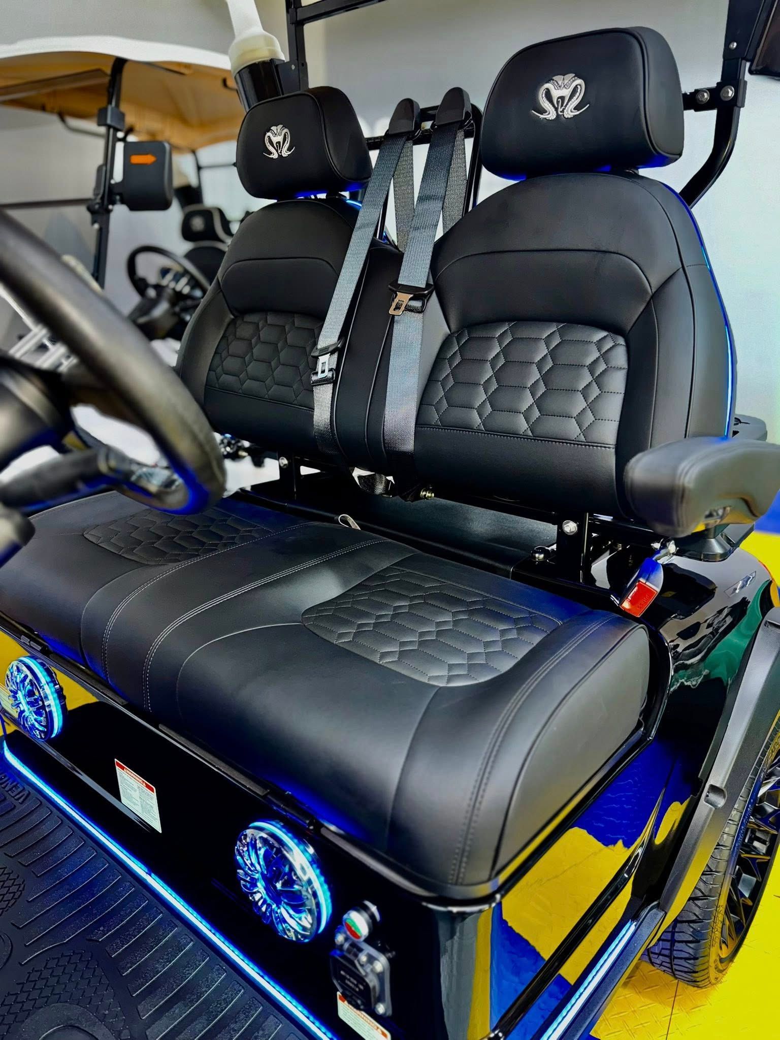 Black and grey golf cart interior with quilted seats, headrests, and blue lights.