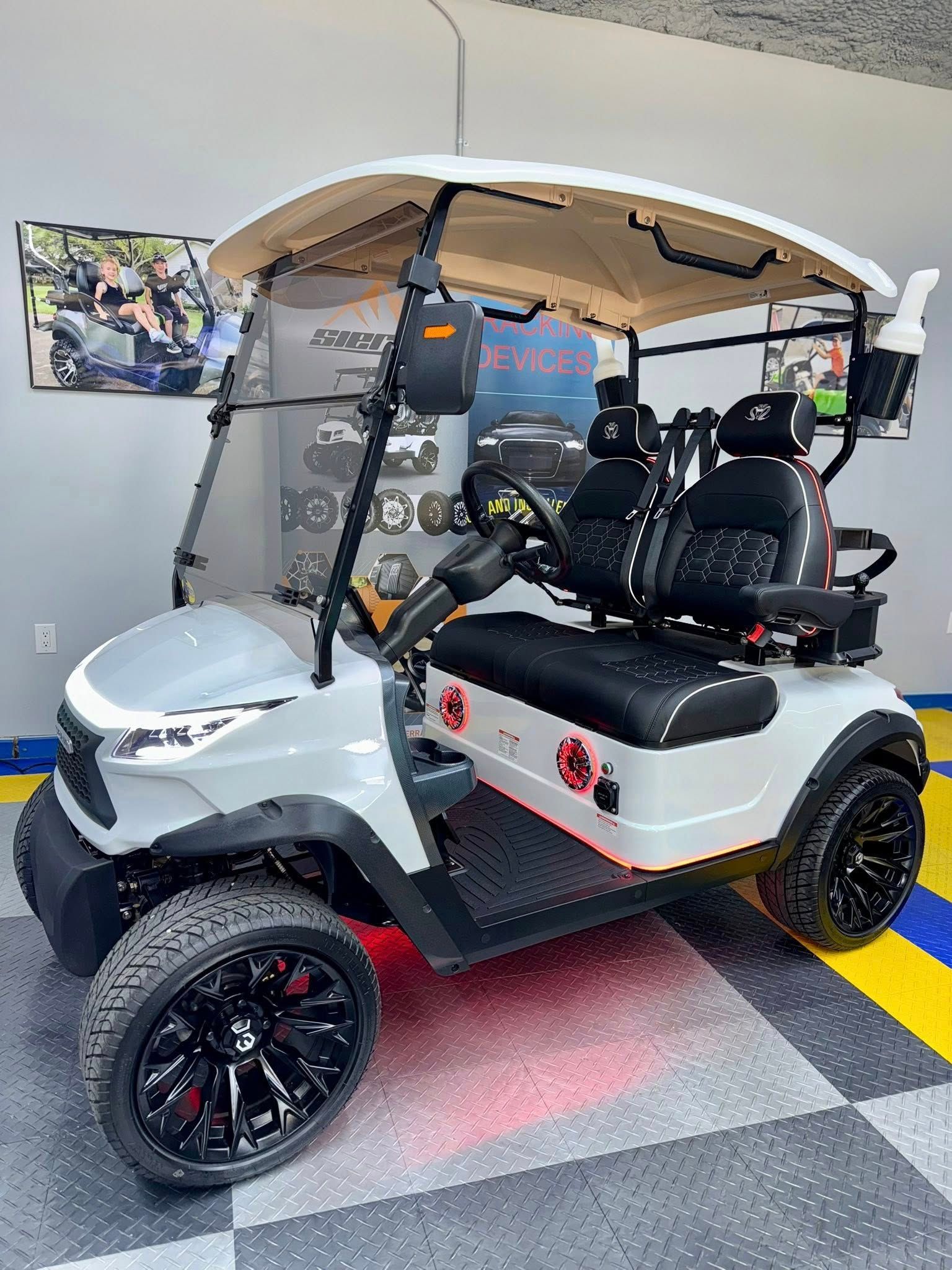 White golf cart with black accents and rims, parked indoors.
