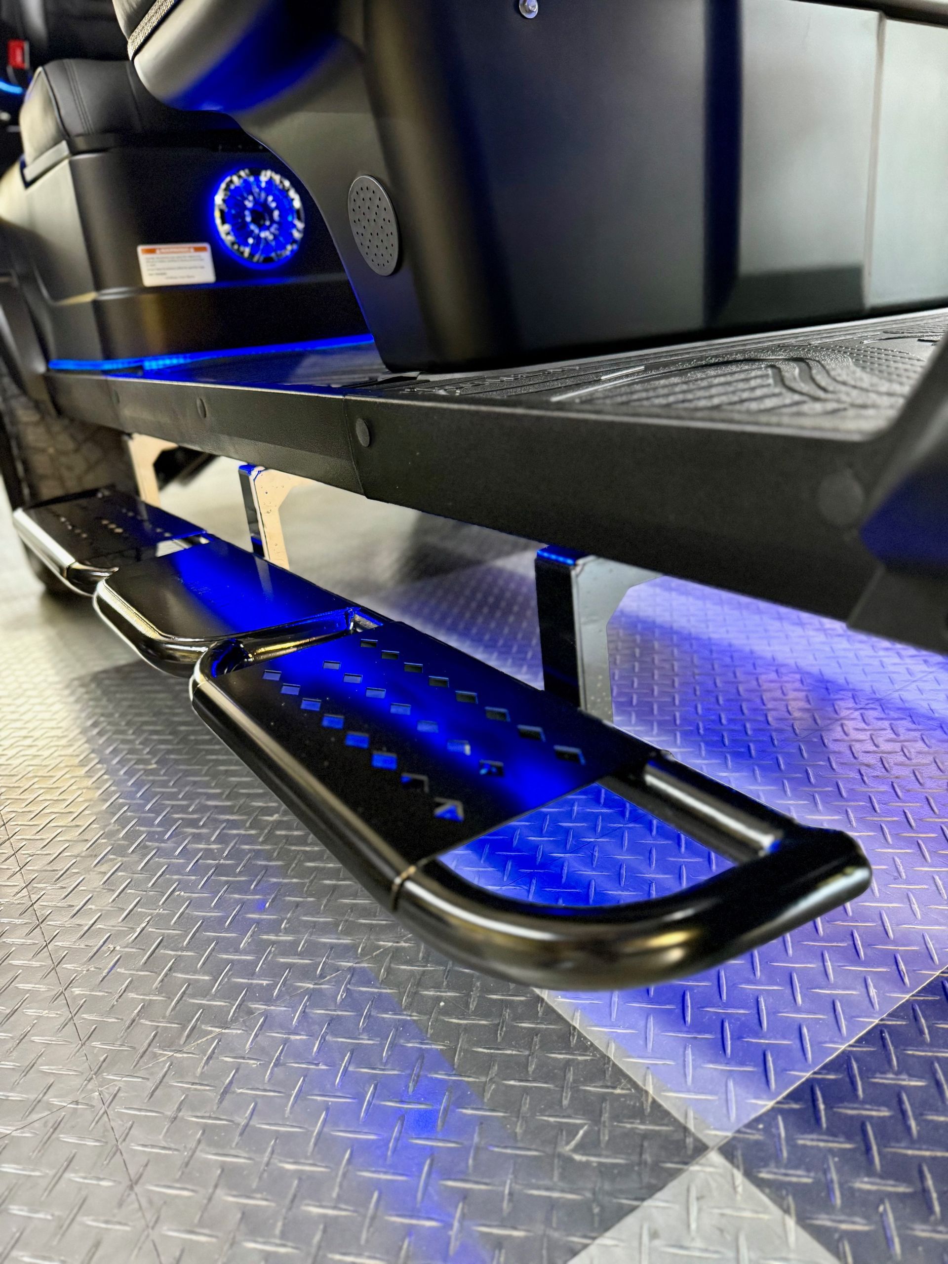Black golf cart with blue underglow and step bar.