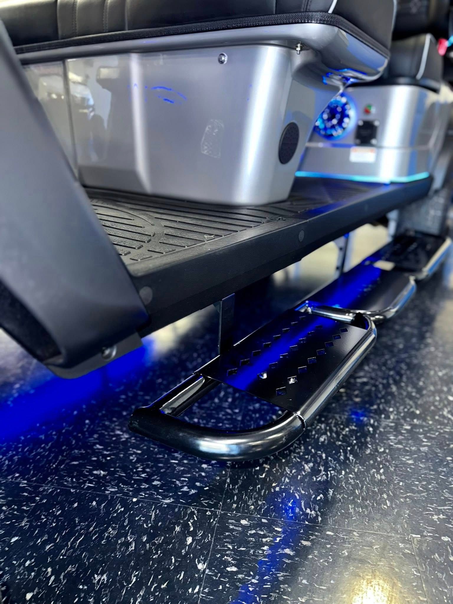 Black vehicle side step with blue underglow lighting.
