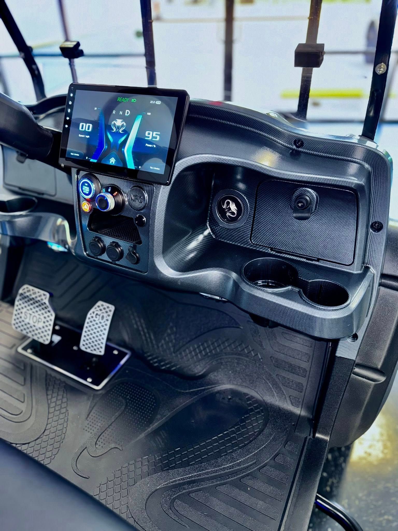 Golf cart dashboard with a digital display, cup holders, and textured black finish.