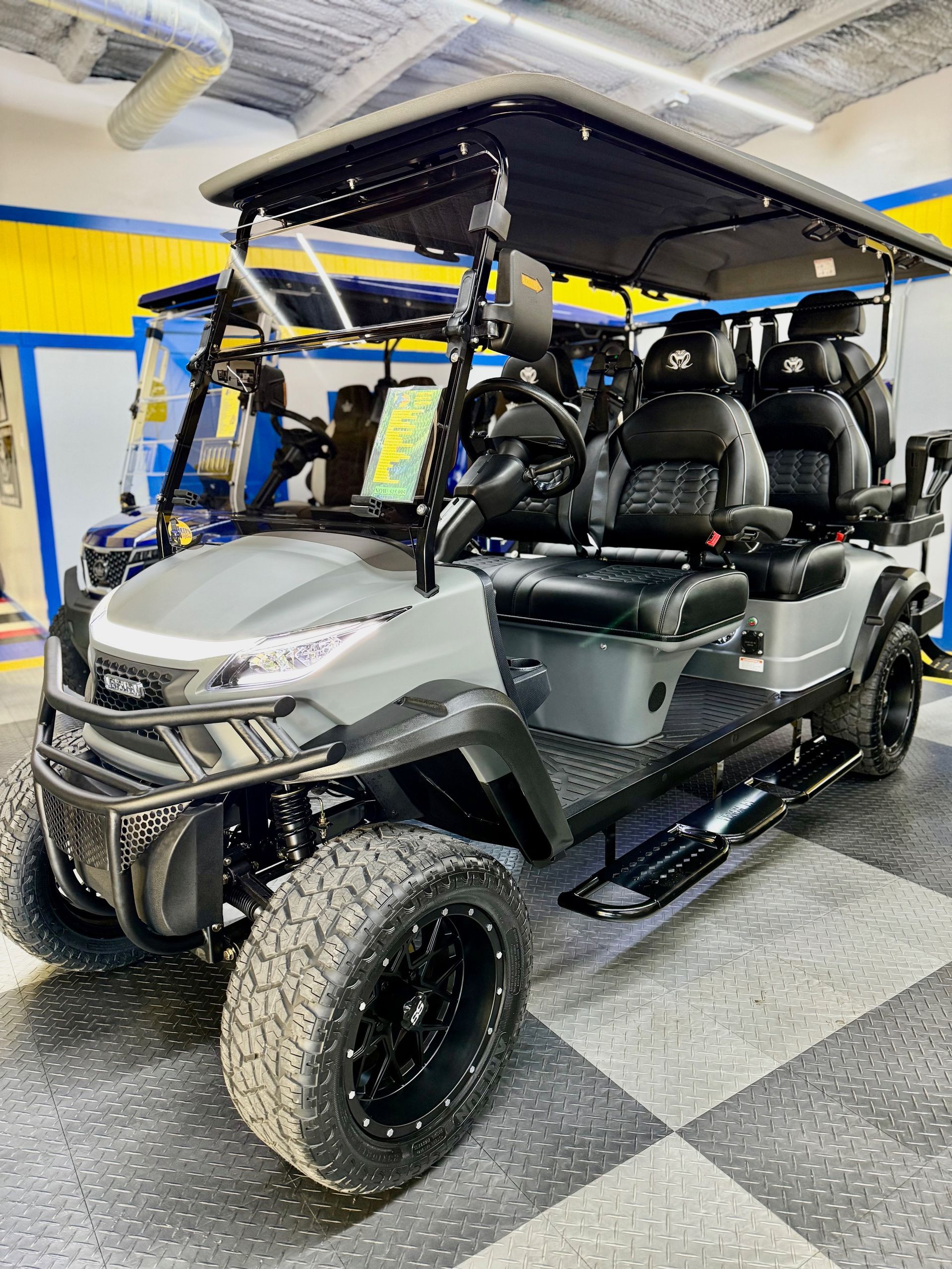 Gray lifted golf cart with black accents and seating.