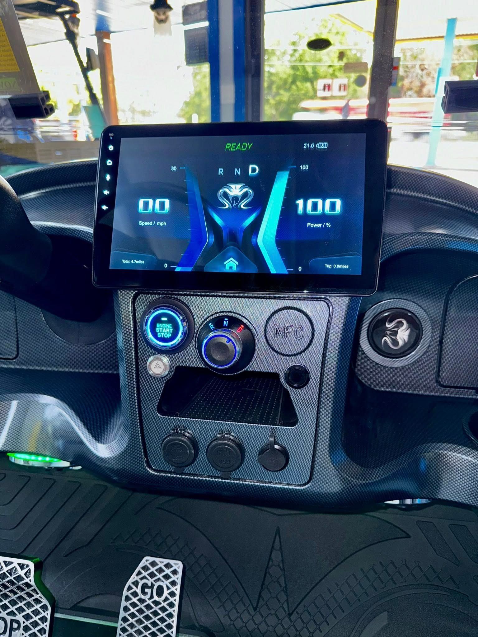 Dashboard with digital display showing speedometer, decorated with carbon fiber details.