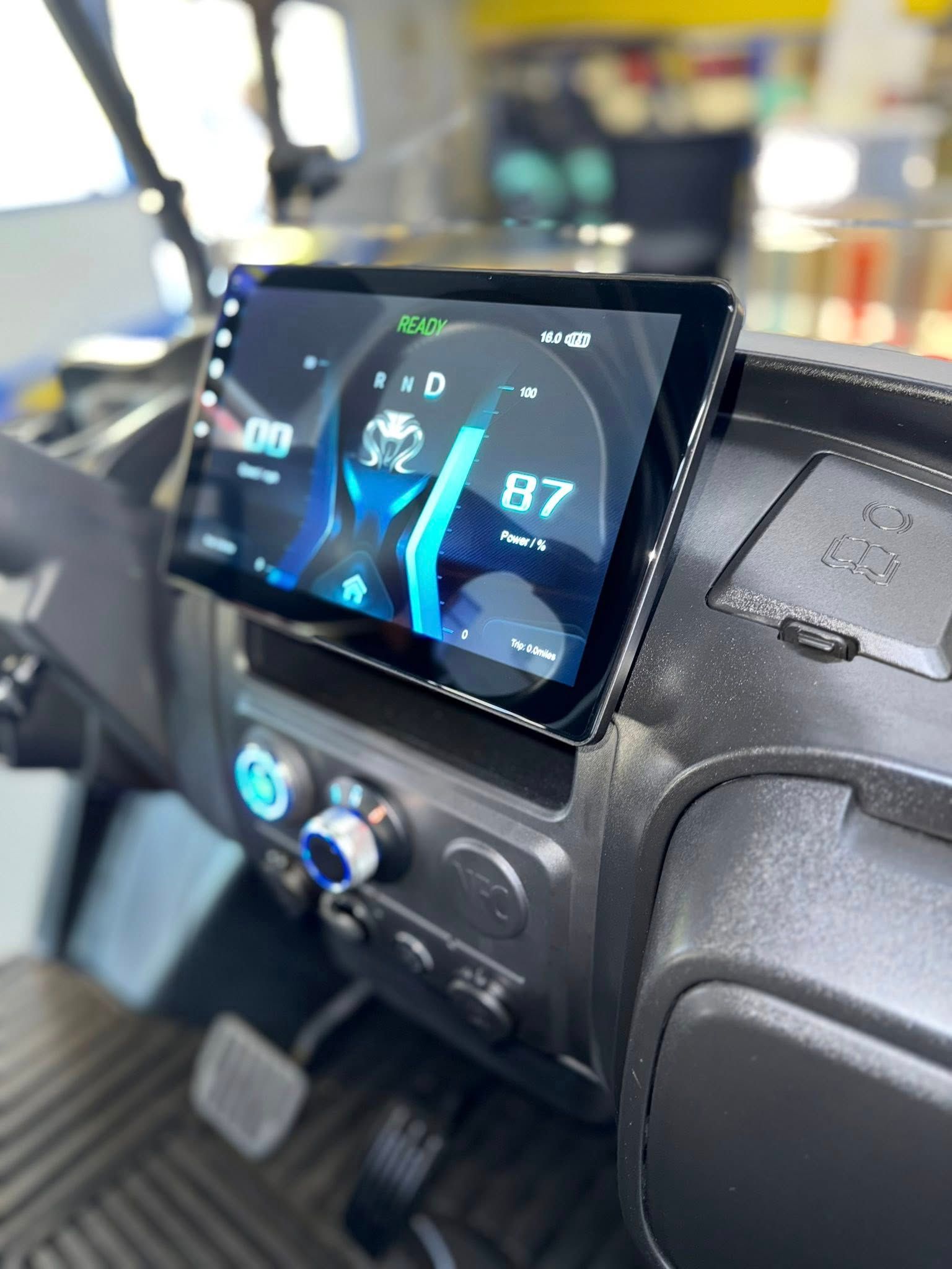 Dashboard with digital display showing speedometer and other vehicle information. Blue and black color scheme.