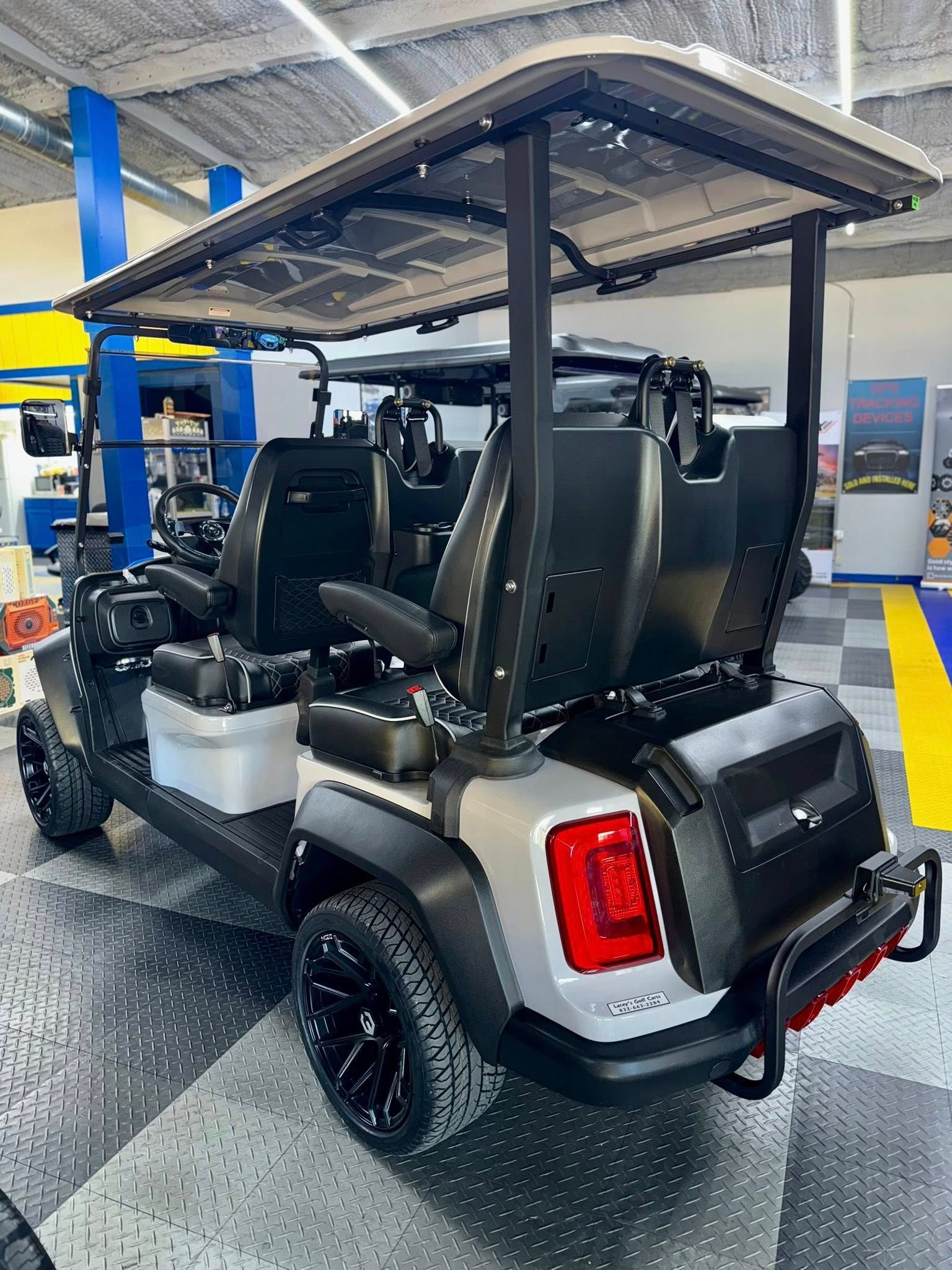 Gray and black golf cart with black wheels, canopy, and taillight.