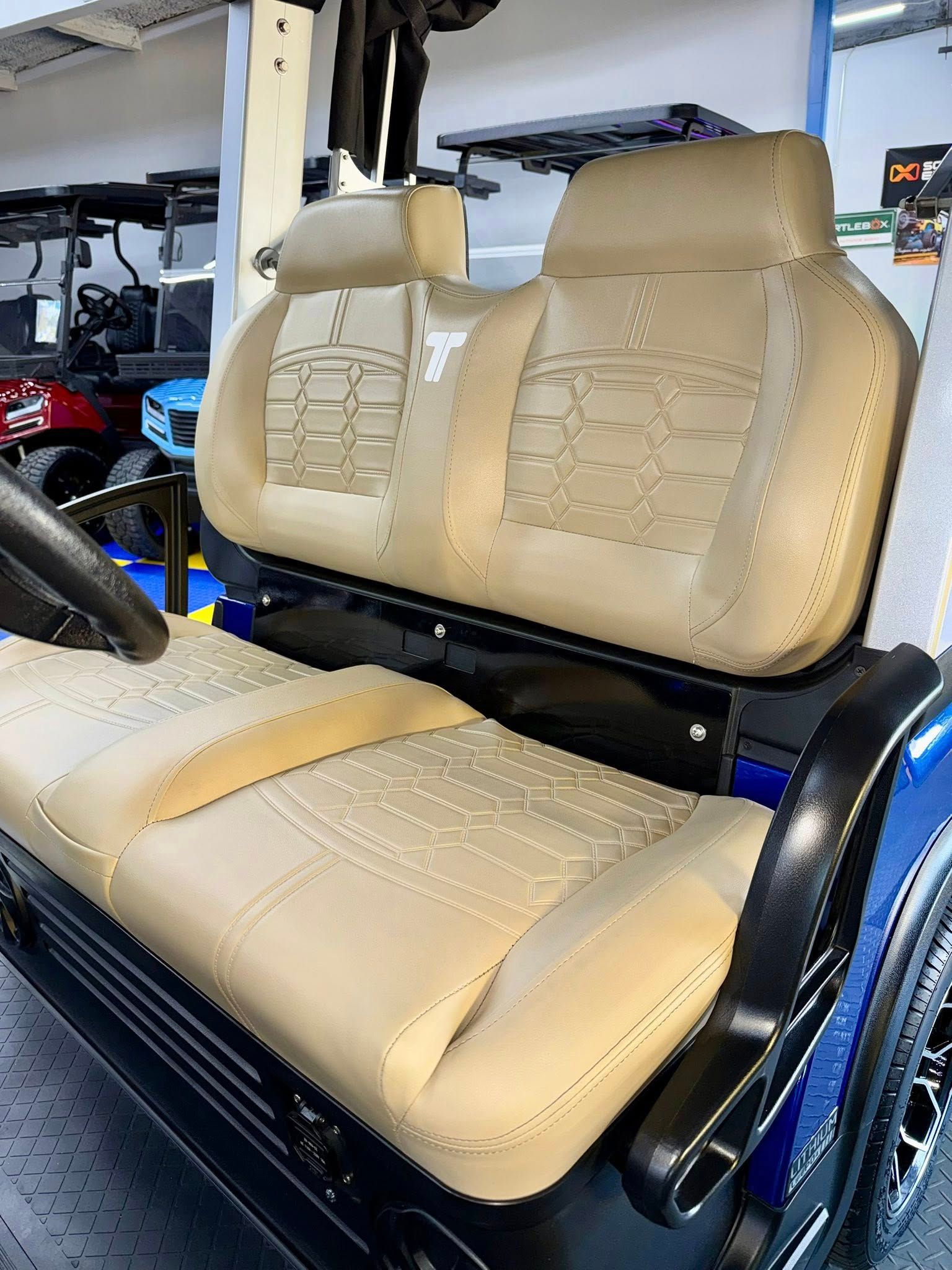 Tan golf cart seats with a blue exterior and black accents.