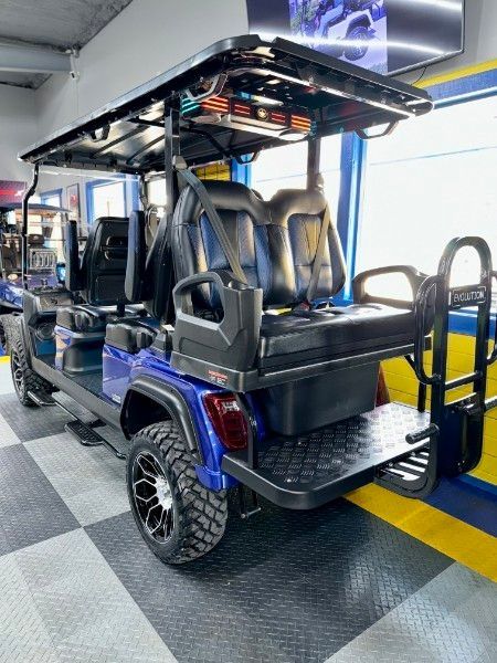 A blue golf cart is parked in a garage.