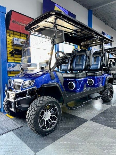 A blue golf cart is parked in a showroom.