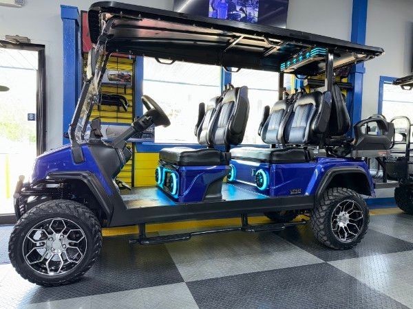 A blue golf cart is parked in a garage.