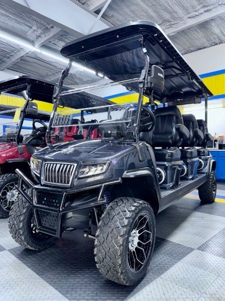 A black golf cart is parked in a garage.