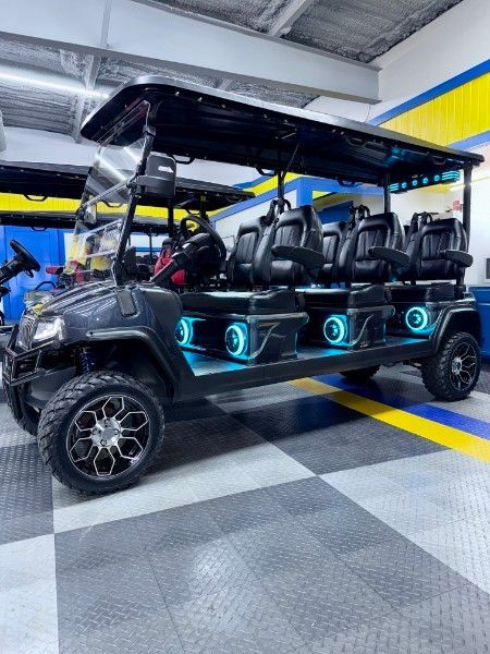 A golf cart is parked in a garage with a checkered floor.
