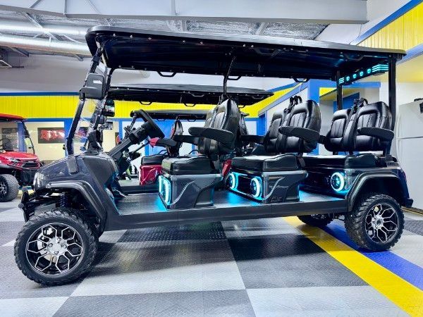 A golf cart is parked in a garage with a checkered floor.
