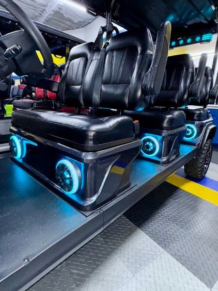 A golf cart with a lot of seats and speakers