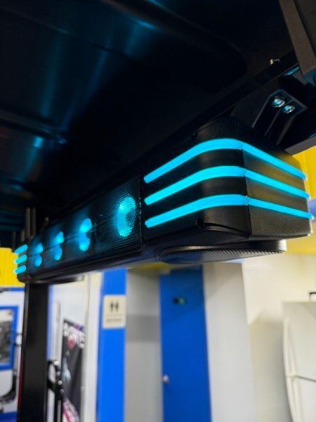 A ceiling mounted speaker with blue lights on it