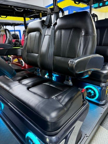 A row of golf carts with black seats and blue lights