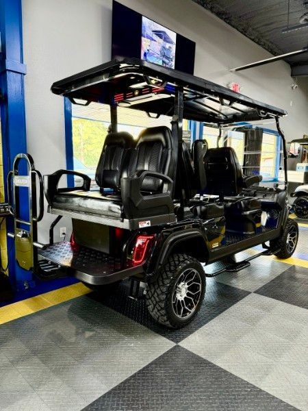 A black golf cart is parked in a garage.