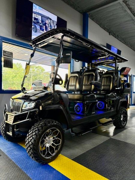 A black golf cart is parked in a showroom.