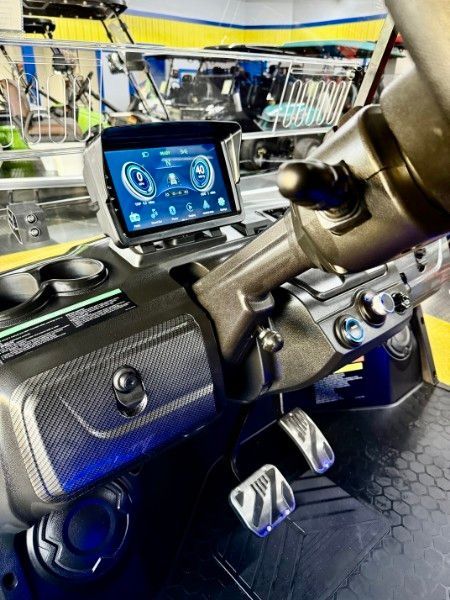 A close up of a car dashboard with a tablet on top of it.